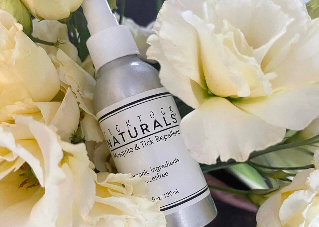 Tick Tock Naturals Spray Bottles surround by white roses