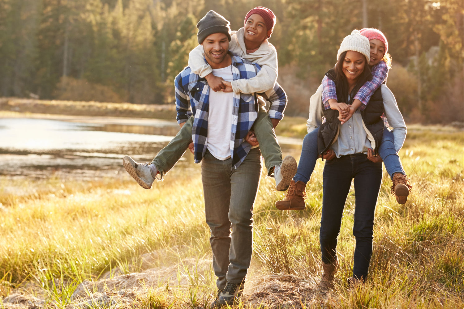 Family of four hiking in autumn next to a lake